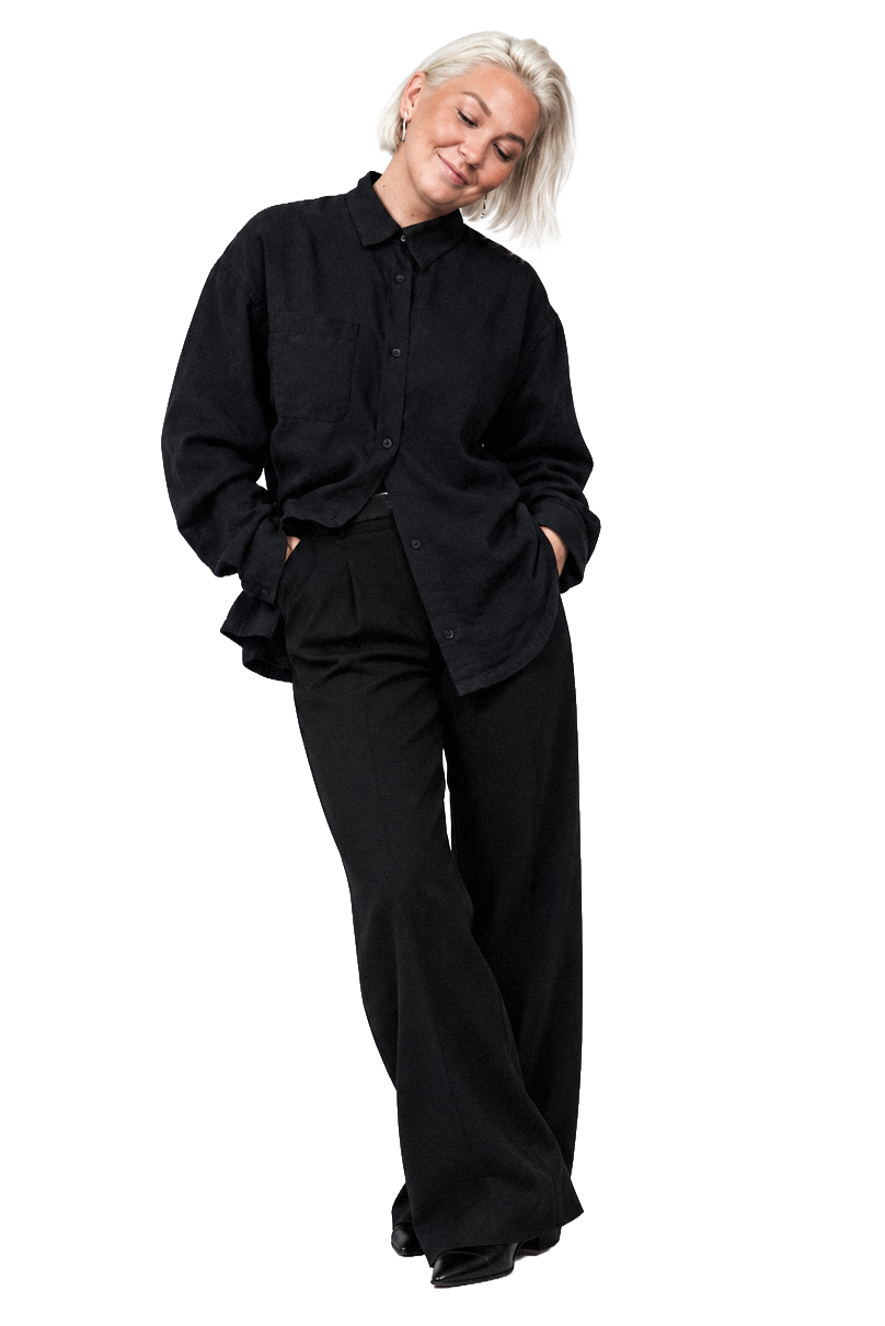 Full-length portrait of Līga Nesenberga in a black shirt and trousers
